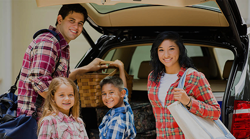 Young Hispanic Family of Four at the back of their vehicle - Free Insurance Quotes